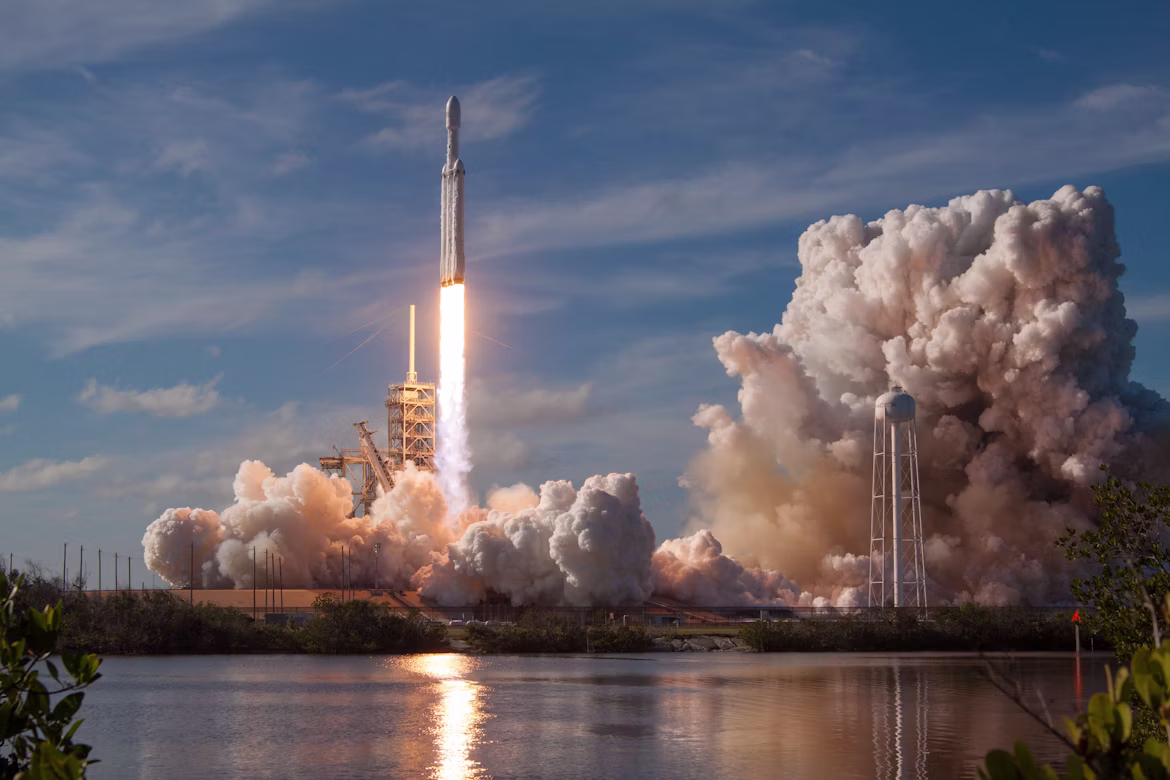 A rocket launches into the sky during daytime